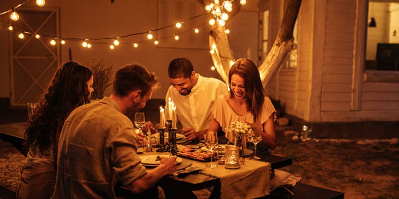 Adults eating dinners in backyard